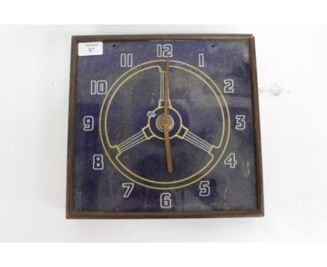 A REVERSE PRINTED GLASS CLOCK depicting an automobile steering wheel and having Arabic numerals 29cm x 28cm 
