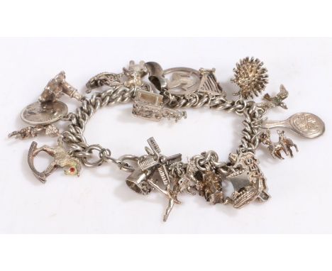 Silver and white metal charm bracelet, containing many charms to include a hedgehog, Isle Of Man pendant, animals and a harp 