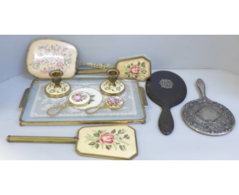A vintage dressing table set, an ebony and silver dressing mirror, a silver toned mirror and a tapestry backed mirror 