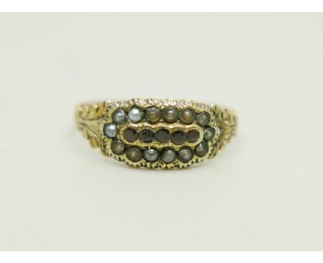 A yellow metal ring set with garnets and a seed pearl border, 1.1g, N, a/f