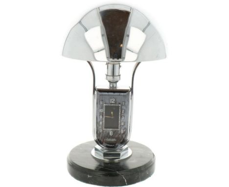 8 day movement, integrated lamp. Chromed shade with marble base. Scratched and with some small dents in the shade. Meas.: 28,