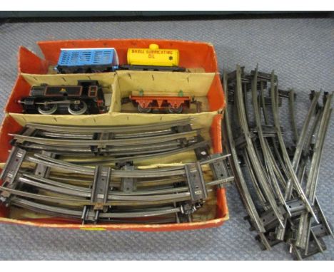 A quantity of Hornby 0 gauge track, a clockwork engine and three carriages 