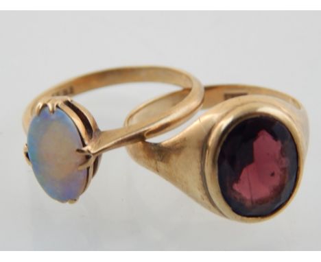 Opal dress ring, the oval stone set in a yellow metal band marked 9ct, a smokey topaz dress ring in a yellow band stamped 9ct