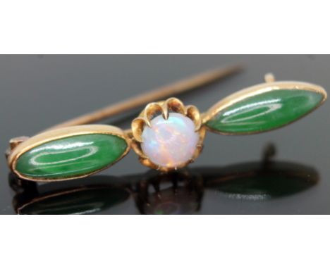 A Chinese gold brooch set with an opal cabochon and two jade coloured stones, marked '20', gross wt. 2.7g, length 34mm.  