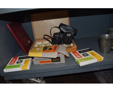 A vintage Johnson Jumbo 22 viewer, two reels of Emitape a slide box and a a Konica camera.