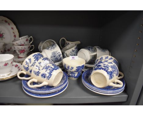 A mixture of blue and white cups,saucers and a jug.