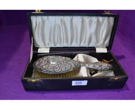 A cased HM silver brush and comb having repousse mask and scroll decoration (AF)