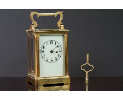 An antique brass cased carriage clock with white enamel dial and complete with key, engraved to the top July 17th 1894. 