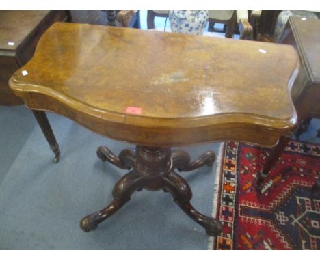 An early 20th century walnut fold over card table standing on four carved scroll legs 74.5cm h x 90cm w 