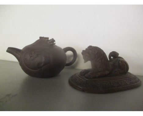 A 20th century Chinese Yixing Zisha pottery teapot and an Indian carved wooden model lion on a plinth 