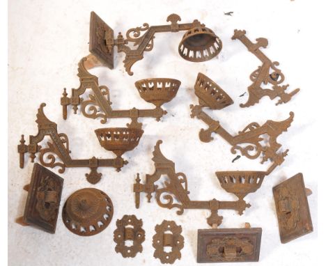 A set of four 19th century cast iron architectural wall sconces. The sconces having shaped arms with recessed decorated panel
