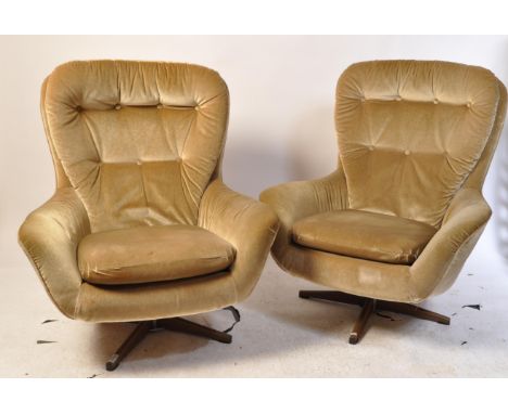 After Arne Jacobsen (1902-1971) - A pair of mid century swivel egg armchairs. Having a button back rest, with drop in cushion