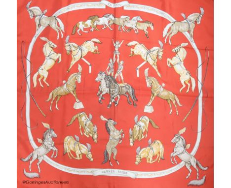   Three vintage Hermes silk scarves, 'Grand Apparat' (red, black and gold), 'En Piste' (red ground) and 'Presentation de Chev