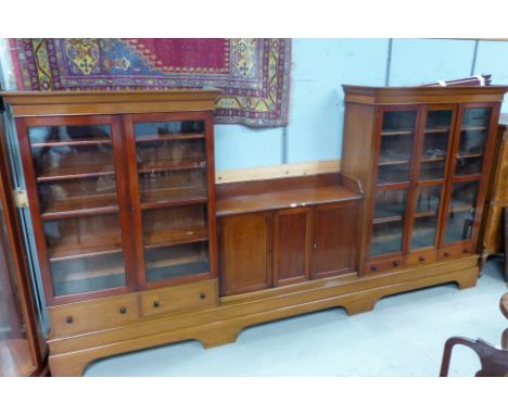 An early 20th century mahogany library bookcase/display unit having 2 end full height glazed cupboards, one enclosed by 3 gla