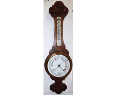 An Edwardian carved oak barometer with thermometer