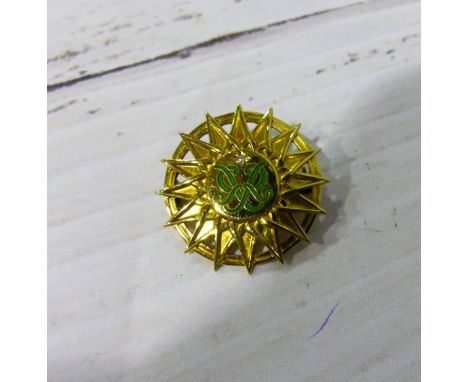 A 9 carat hallmarked gold sunburst brooch with inset diamond and green enamel decoration, 5.9 gm 