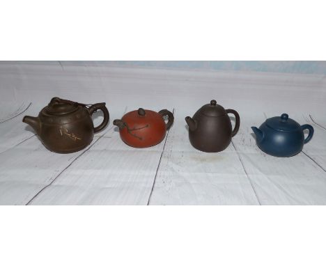 Two Yixing brown teapots; a similar blue teapot; and another