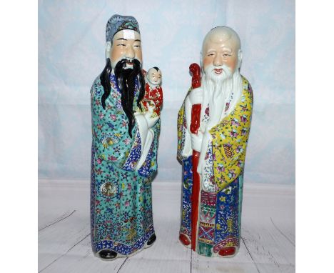 A pair of Chinese large figures of immortals in the Cantonese manner, one with a child, and one with a stick