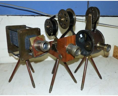 Two reproduction cinema cameras on legs; a similar bellows camera