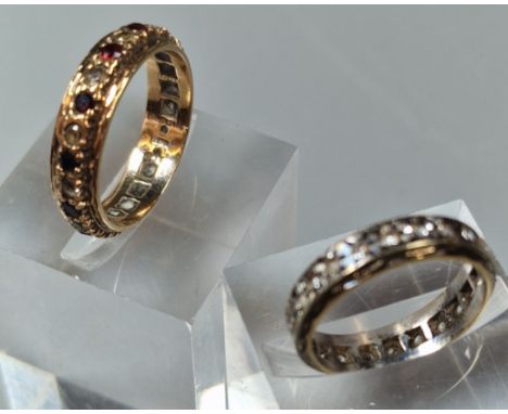 9ct gold clear and red stone full eternity ring. 2.9g approx. Size N. Together with 9ct clear stone full eternity ring. 3.1g 