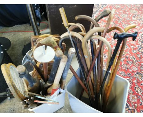 Large collection of assorted walking sticks and sports equipment to include: tennis rackets, cricket bats with wickets etc. (