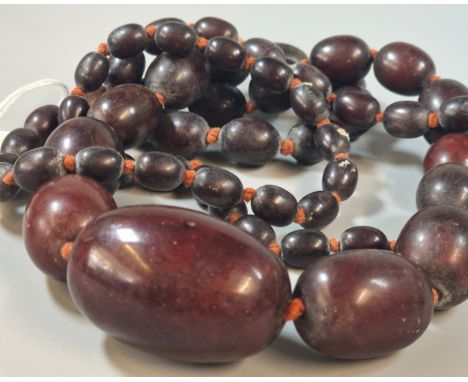 Art Deco design cherry amber type graduated necklace, of large proportions. 124cm long approx. 207g approx. Largest bead 5cm 