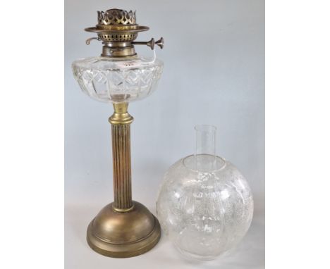 Early 20th century double oil burner lamp, having etched globular shade above a clear cut glass reservoir, on brass base. (B.