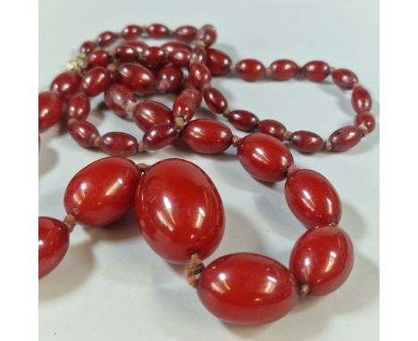 Art Deco design red cherry amber type graduated beaded necklace. 90cm long approx. 71g approx. Largest bead 3.2cm long approx