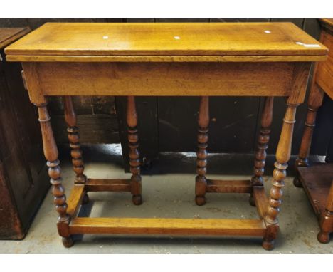 Gwilym C Price, reproduction oak fold-over writing desk, the pullout drawer standing on bobbin and baluster turned legs, with