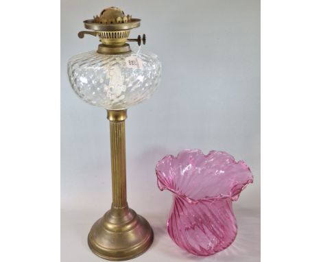 Early 20th century double oil burner lamp, having writhen frilled cranberry glass shade above clear and moulded glass reservo
