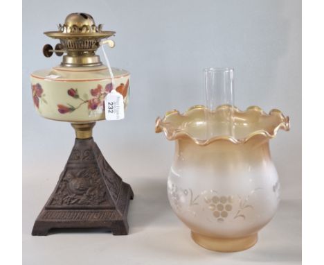 Early 20th century double oil burner lamp, having a frosted and orange shade, above a mustard ground hand-painted reservoir, 