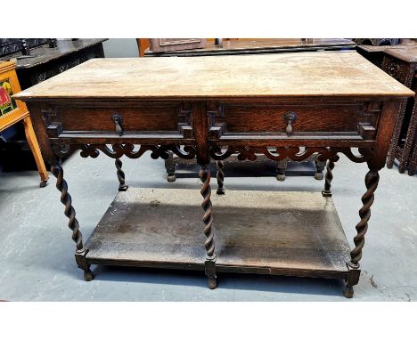 Early 20th century oak Jacobean style dresser base, the moulded top above two fitted drawers, with carved frieze on barley tw