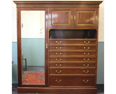 An Edwardian mahogany wardrobe, with moulded cornice and mirrored door, with two cupboard doors, shelf and seven graduated lo