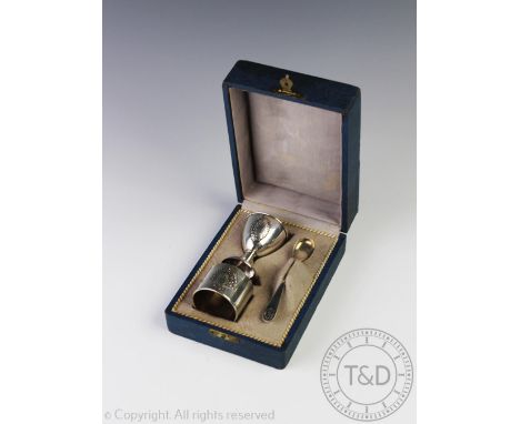 A cased '800' standard silver Christening set, comprising; egg cup, spoon and napkin ring, each piece with vacant cartouche, 