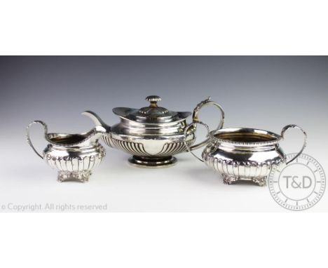 An assembled three piece silver tea service, each piece of low rounded form, with fluted detail, comprising; a tea pot George