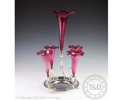 A silver plated and cranberry glass centrepiece epergne,  modelled with a central glass trumpet vase and four smaller, on cir