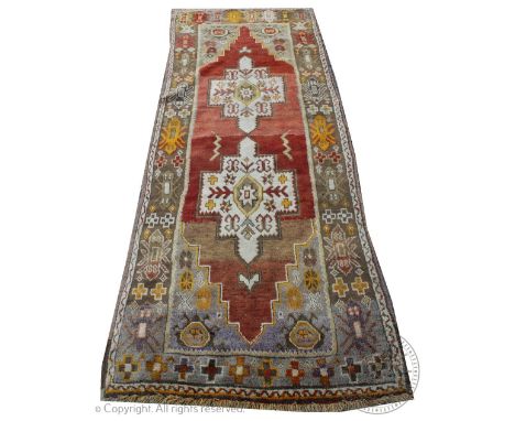 A Persian full pile wool runner, worked with two gulls against a red ground in pale colours, 295cm x 105cm