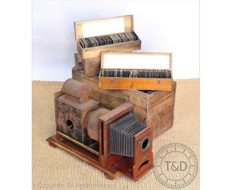 A Victorian magic lantern titled 'The Tudor Enlarger', accompanied with a collection of cased photographic slides including T