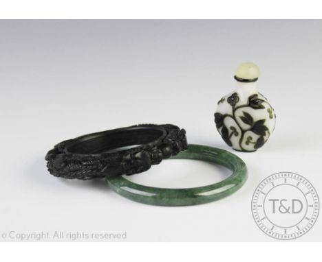 A Chinese glass overlay snuff bottle, decorated with black sprays against a opaque white body, 6.5cm high and a green Jade ba