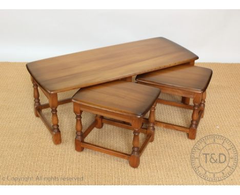 A nest of three Ercol dark light wood coffee tables, on turned legs, the largest 41cm H x 114cm W x 49cm D, a pair of Ercol s