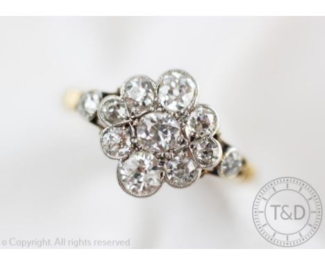 A diamond set daisy cluster ring, designed as a central old cut diamond within a surround of eight graduated further old cut 