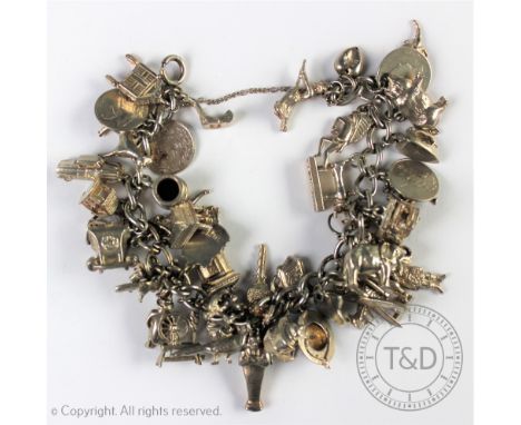 A silver charm bracelet, the flat curb link chain hung with numerous silver and white metal charms, to include; a foxes mask,