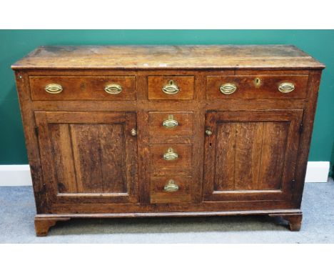 A George III oak dresser base, with three drawers over cupboards, on bracket feet, 140cm wide x 91m high.