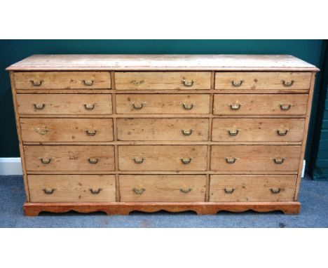 A Victorian pine bank of three rows of five graduated drawers, on bracket feet, 180cm wide x 99cm high.