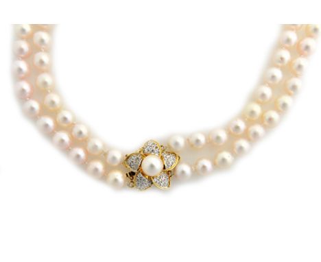 A two row necklace of uniform cultured pearls, on a gold, diamond and cultured pearl set clasp, designed as a flowerhead, det