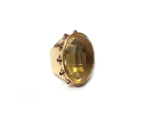 A 9ct gold ring, mounted with an oval cut large citrine to the centre, within a surround of cabochon rubies, in a Game of Thr