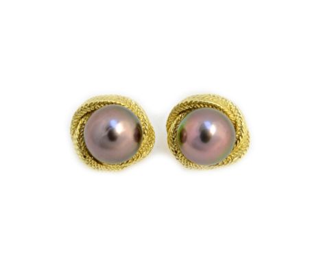 A pair of gold and black tinted cultured pearl earclips, each mounted with a large black tinted cultured pearl, within a cast
