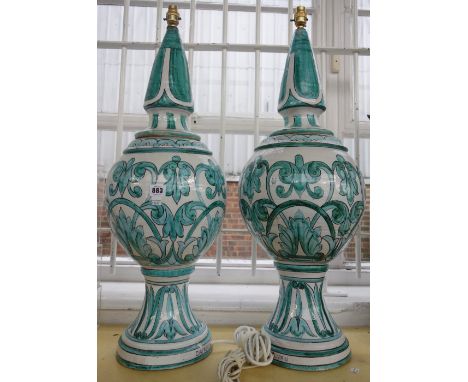 A pair of modern Spanish pottery table lamps, decorated with stylized green foliage against a white ground, detailed 'Casasus