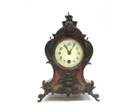 A German walnut cased mantel timepiece, late 19th/early 20th century, with white enamel dial and waisted case, with metal fol
