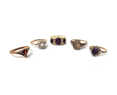 A gold, amethyst and diamond ring, claw set with three oval cut amethysts and with two diamond set four stone divisions at in